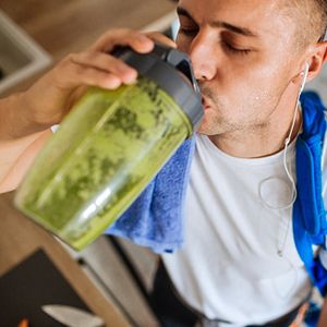 man drinking green smoothie