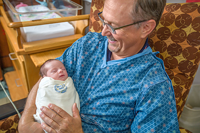 Man rocks a newborn baby to sleep